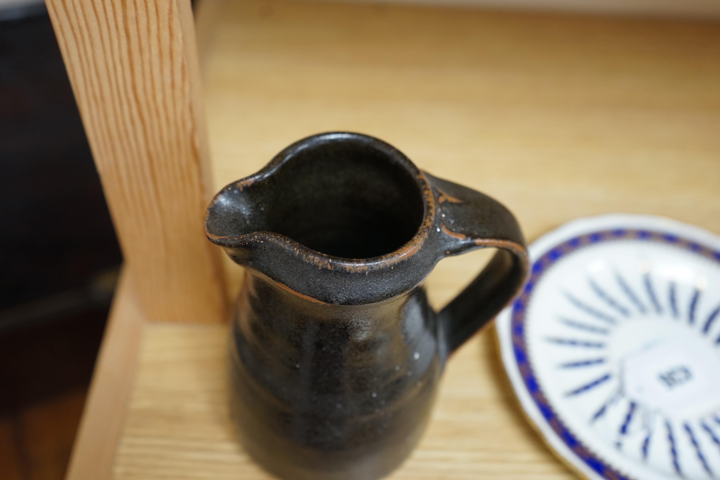 Leach standard ware, a small Stoneware black glazed studio pottery jug, impressed mark to top of foot rim, 15.5cm high. Condition - good